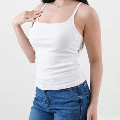Person wearing a white tank top and blue jeans on a plain background