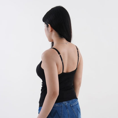 Woman wearing a black tank top and blue jeans on a white background